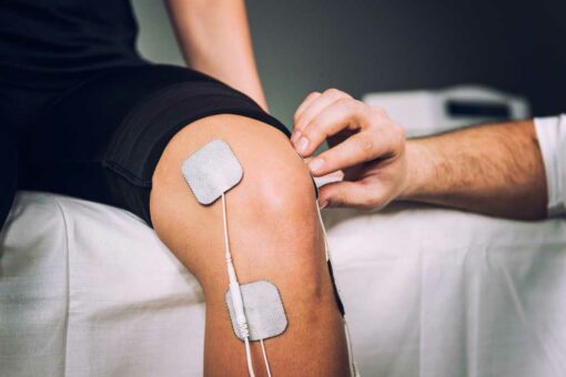 Sports TENS -smärtlindrare elektroder på knä